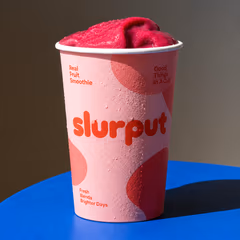 A Slurput smoothie cup on a blue table